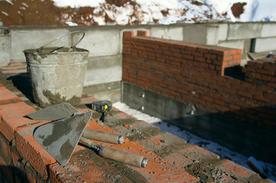 Construction Tools and Bucket on Brick Wall